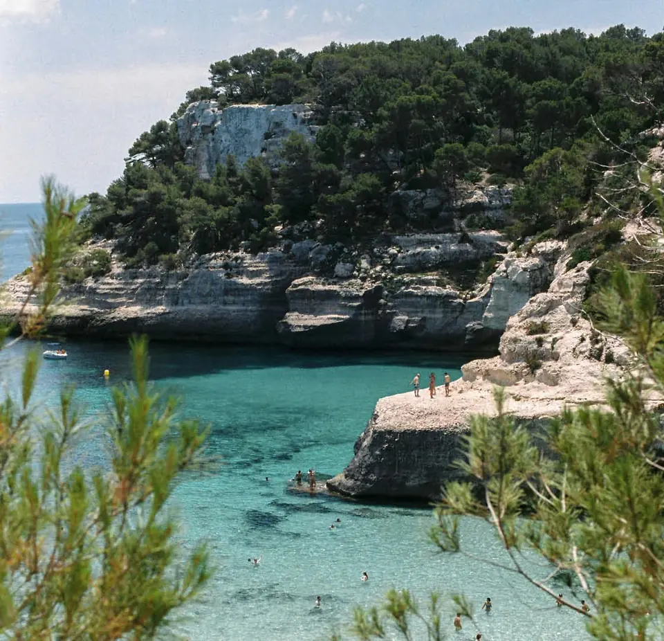 Cala de aguas turquesa entre acantilados y pinares